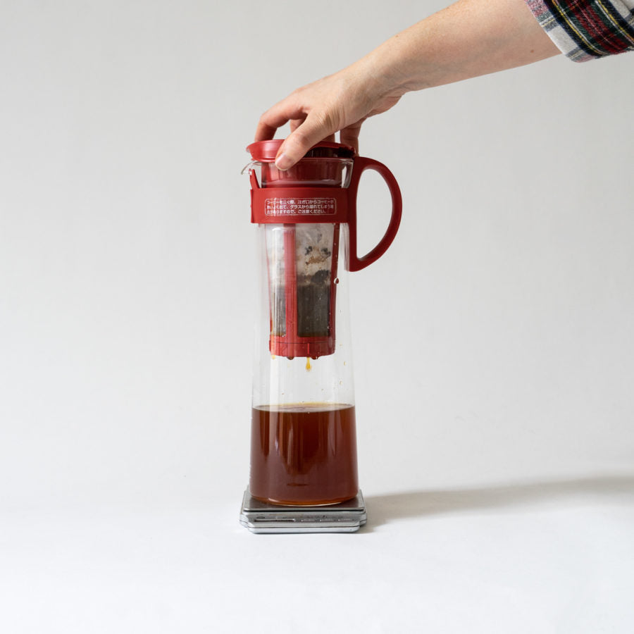 A hand holding a coffee maker