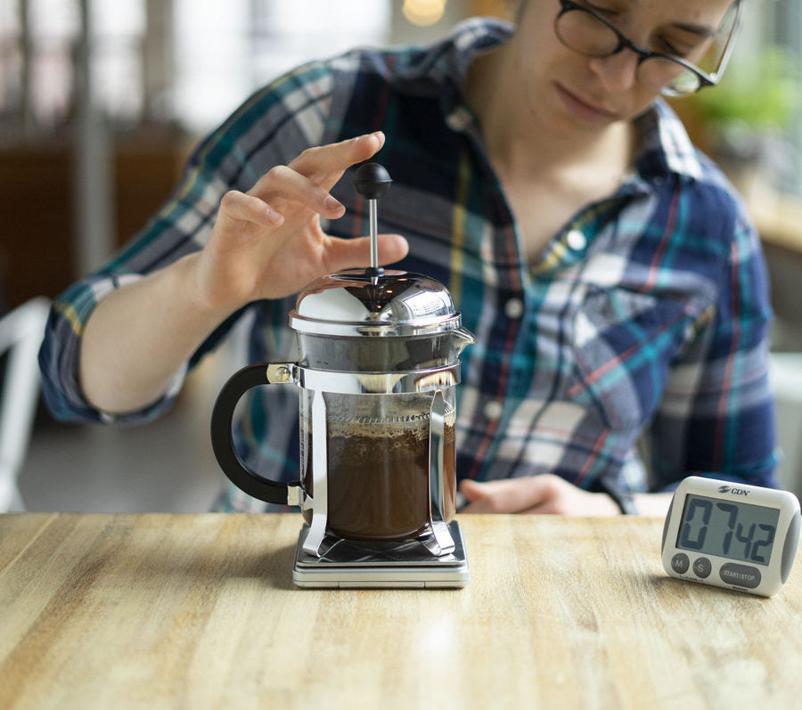 A person using a coffee press