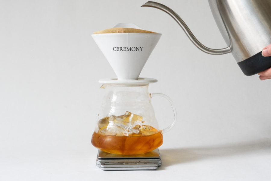A person pouring liquid into a glass container