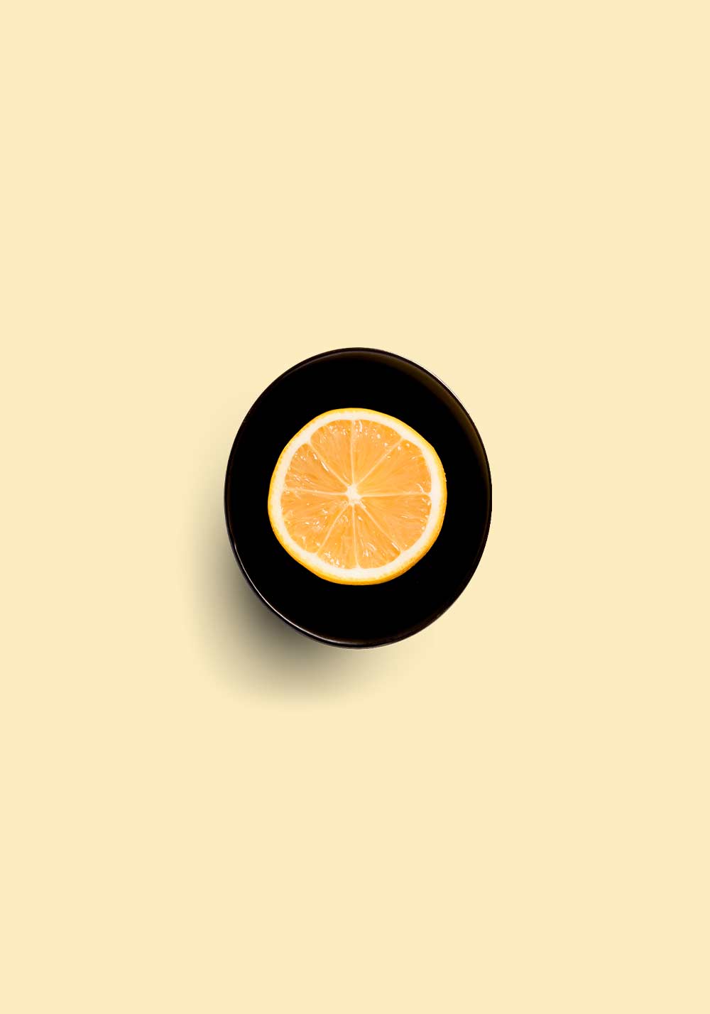 Top view of a lemon slice on a black surface representing Colombia El Paseo with citrus and floral notes
