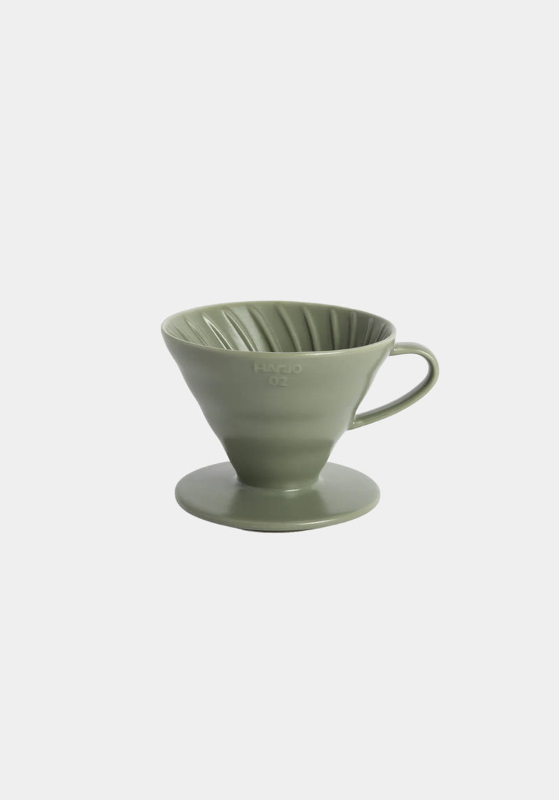 Green ceramic coffee dripper on a white background