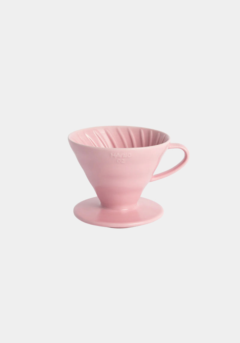Pink ceramic coffee dripper on a light pink background