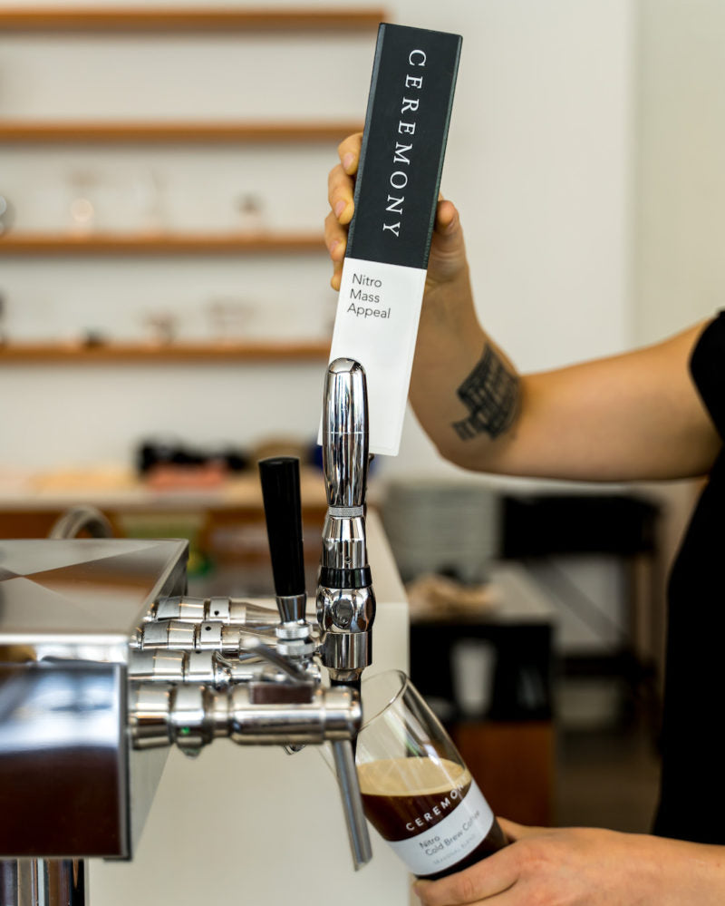 Barista pouring Nitro Cold Brew from a stout tap at a Baltimore location