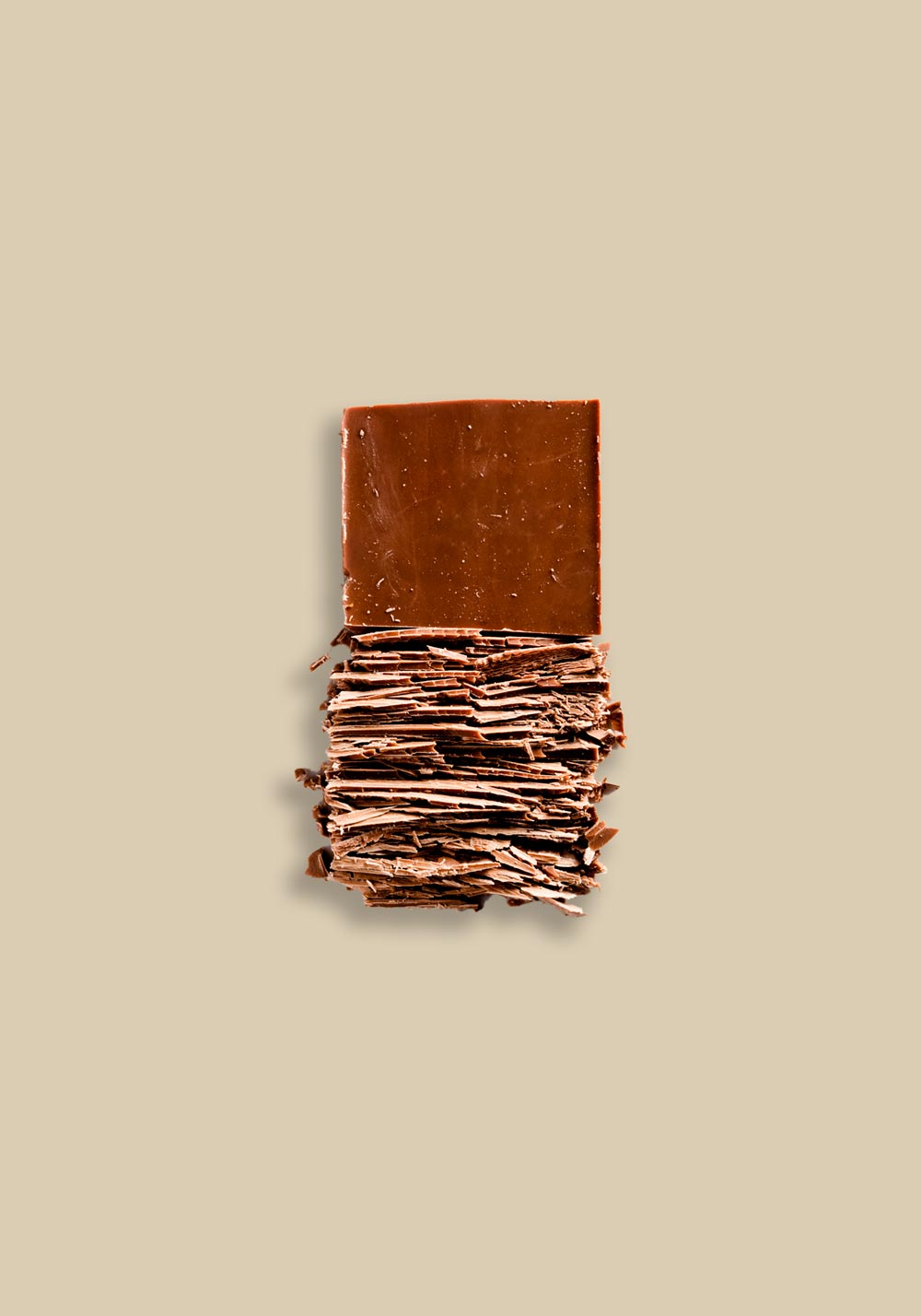Peru Cenfrocafe 10.00% Off Auto renew - Artfully stacked layers of rich brown chocolate broken into thin, textured pieces, displayed against a neutral beige background, showcasing the delicate, flaky texture and high-quality appearance of the chocolate.