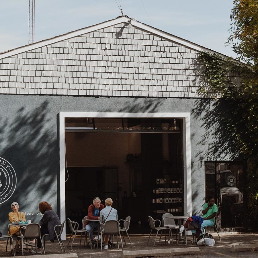 Guests chatting and enjoying coffees outside the Roastery location.