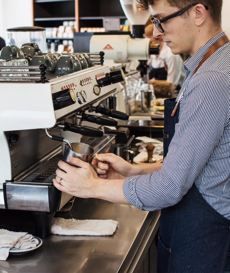 Barista steaming milk on a La Marzocco FB80 machine.