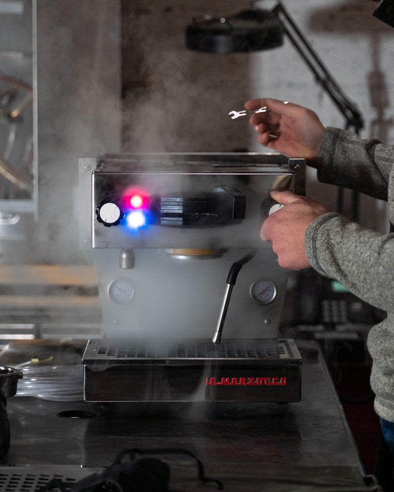 Equipment services manager testing steam wand on La Marzocco Linea Mini.