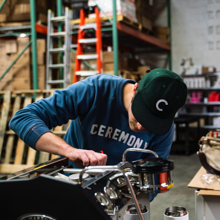 Busy equipment technician repairing a La Marzocco espresso machine